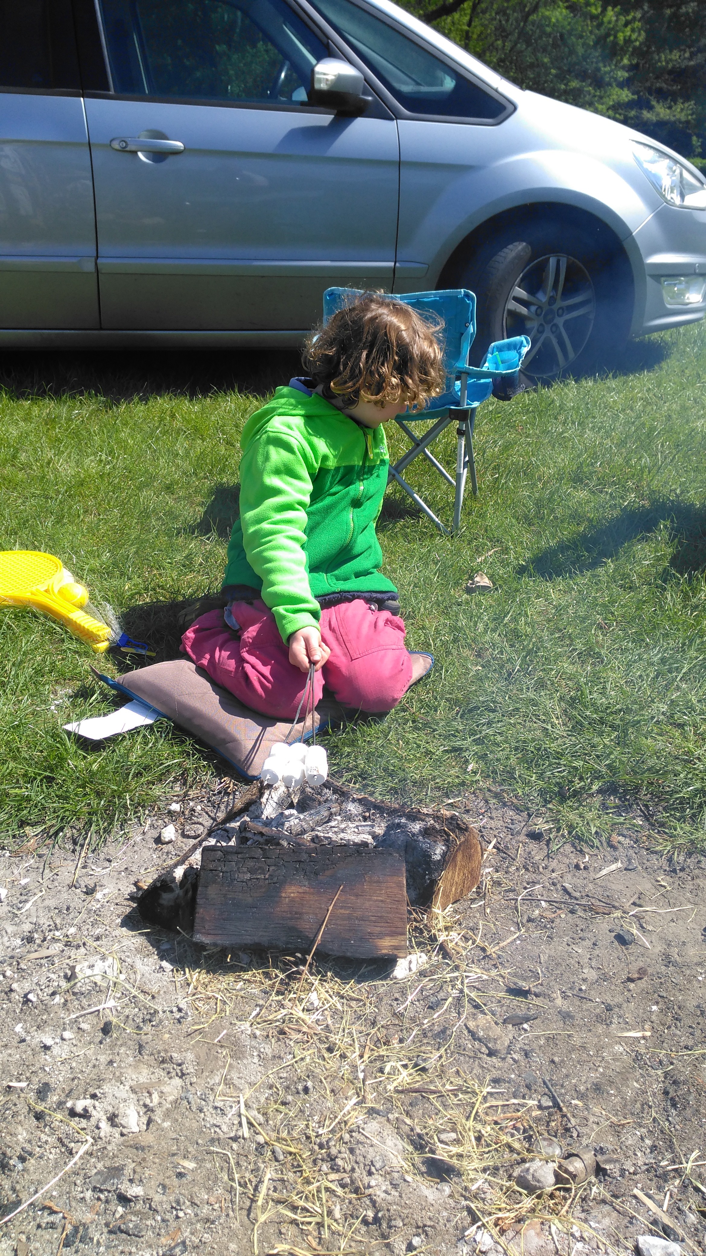 Cooking marshmallows on his own fire